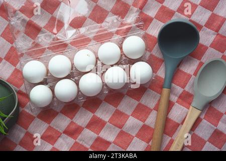top view of eggs in a plastic container and spoon on table . Stock Photo