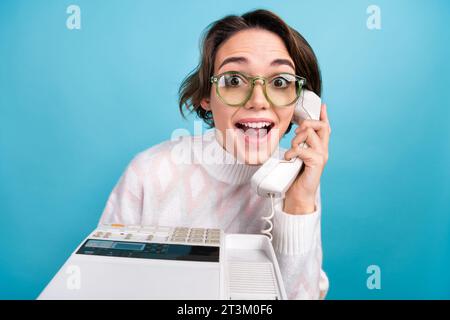 Portrait of impressed funky person communicate speak retro cable telephone isolated on blue color background Stock Photo