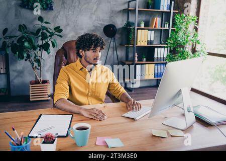 Photo of confident successful man sitting working codding program online modern office room Stock Photo