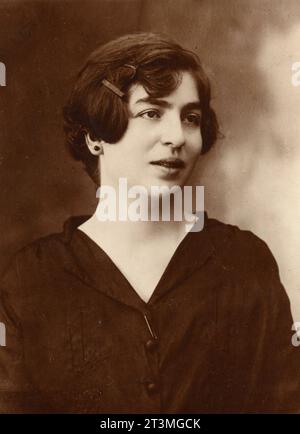 Studio portrait close-up of a young woman with short brown hair and dark dress, Italy 1910s Stock Photo
