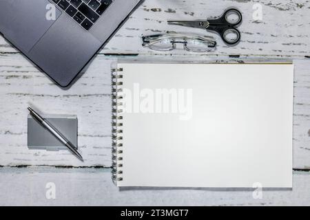 Top view on office desktop with labtop, glasses, pen and paper Stock Photo