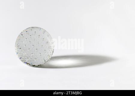 Translucent crystal globe with bubbles made of glass inside casting shadow against gray background Stock Photo