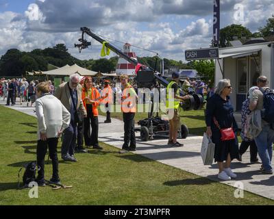 Visitors, Gardeners' World film crew & stewards (hi-vis vests) walking & standing - busy showground, RHS Flower Show Tatton Park, Cheshire England UK. Stock Photo