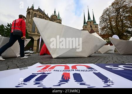 26 October 2023, Thuringia, Erfurt: Nine of a total of 100 five-meter-long paper boats, which will be set up in front of the Bundestag for World Refugee Day on June 20, 2024, will be presented on Erfurt's Domplatz. The project of the AWO Volunteer Academy Saxony-Anhalt reminds nationwide with 100 paper boats of about 100 million people who are on the run worldwide. Photo: Martin Schutt/dpa Stock Photo