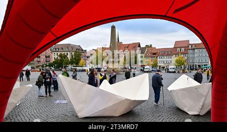 26 October 2023, Thuringia, Erfurt: Nine of a total of 100 five-meter-long paper boats, which will be set up in front of the Bundestag for World Refugee Day on June 20, 2024, will be presented on Erfurt's Domplatz. The project of the AWO Volunteer Academy Saxony-Anhalt reminds nationwide with 100 paper boats of about 100 million people who are on the run worldwide. Photo: Martin Schutt/dpa Stock Photo