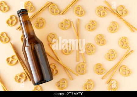 Beer bottle and pretzel background on yellow background. Copy space. Flat lay. Stock Photo