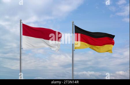 Germany and Indonesia and Bali flags waving together on blue cloudy sky, two country relationship concept Stock Photo