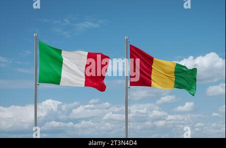 Republic of Guinea and Italy flags waving together on blue cloudy sky, two country relationship concept Stock Photo