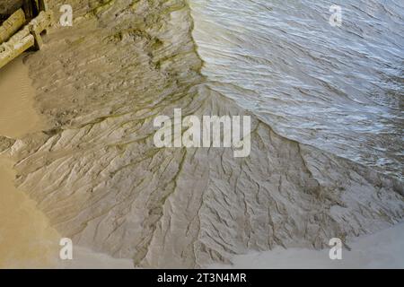 Mud when the tide goes out. Near City of Wine (Cite du Vin) sticky, slimy, brown, mud, with clay-like colour. Maybe silt built up near to flood gates? Stock Photo