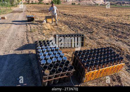 A technician sets up a battery of launchers for 4' pyrotechnic shells being prepared for a fireworks show in a field in Utah. Stock Photo