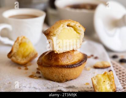 Pasticciotto leccese pastry filled with egg custard cream, typical sweet from Lecce, Italy. Pieces of pasticiotto on a beige napkin, apulian breakfast Stock Photo