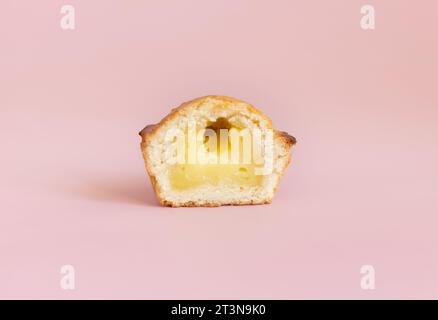 Pasticciotto leccese pastry filled with egg custard cream, typical sweet from Lecce, Italy. Half of baked pasticiotto on a pink, apulian breakfast, cl Stock Photo