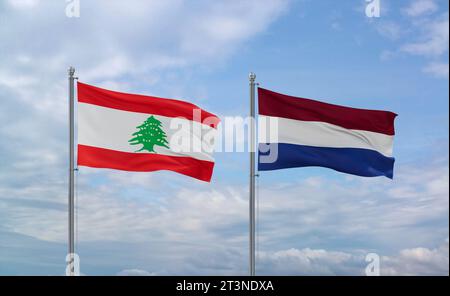 Netherlands and Lebanon flags waving together on blue cloudy sky, two country relationship concept Stock Photo