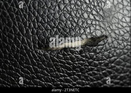 black leather background with damaged surface, furniture repair