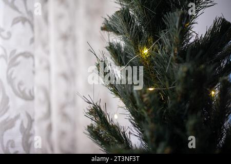 Close-Up of a Home Christmas Tree Decorated with Warm Mini Fairy Lights for a Festive Holiday Atmosphere Stock Photo