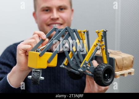 Nuremberg, Germany. 26th Oct, 2023. Inventor Jonas Heinzler (Artur Fischer Inventor Award) presents the self-balancing 2-wheel loader using a model during the Innovation Show at the International Inventors' Trade Fair 'iENA'. According to the inventor, the vehicle offers the perfect balance between payload and dead weight to ensure overhead loads and reduce floor loading. The International Trade Fair for Ideas, Inventions and New Products (iENA) will showcase 800 inventions to the trade public from Oct. 28 to 30. This year's partner country is China. Credit: Daniel Karmann/dpa/Alamy Live News Stock Photo