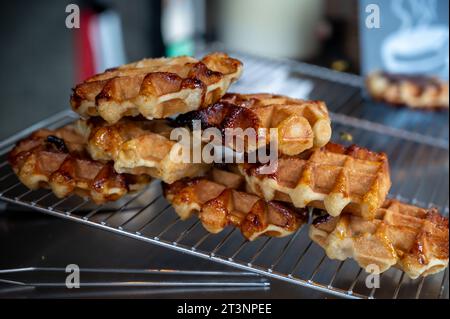 Eating of fresh baked hot Belgian sugar waffles, street food in Bruges, Brussels, Belgium Stock Photo