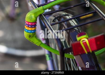 Close up of colorful bike lock on wheel and pack carrier Stock Photo