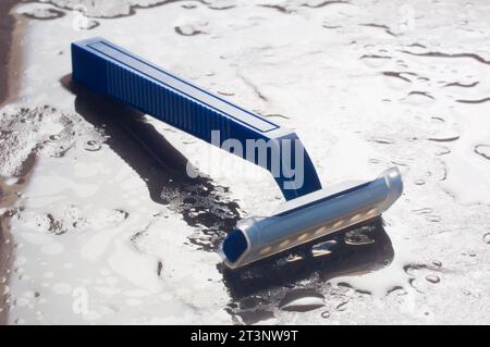 Studio shot of a plastic disposable razor on a wet slate background - John Gollop Stock Photo