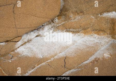 Sea salt dried on orange, cracked sandstone Stock Photo