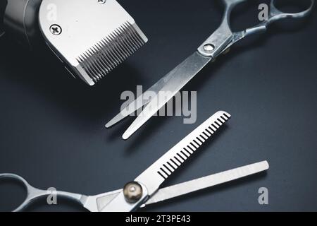 Mens hairdressing desktop with tools for shaving top view. Male haircut, fashion. Hair clipper and Hairdresser scissors on black background. Accessori Stock Photo