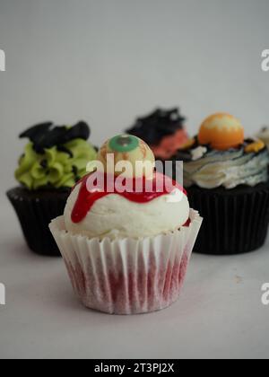 a set of horror halloween themed artsy cupcakes muffin isolated on white Stock Photo