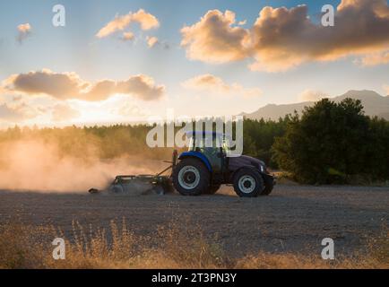 Seed field preparation with tractor. Improvement of the land with tractor. Preparation time for sowing-planting season. Ploughing works with construct Stock Photo
