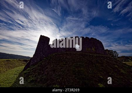 The ancient walls of a castle are starkly silhouetted against a dramatic blue sky at Restormel Castle, Cornwall, England. Stock Photo