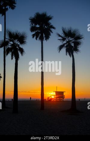 Silhouetted lifeguard hut and palm trees during a colorful sunset at Venice Beach in Los Angeles, California. Stock Photo