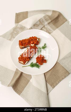 On the table are sandwiches made from buckwheat bread, butter and adjika. Vertical frame. Stock Photo
