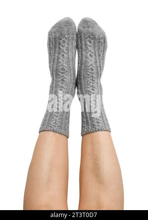 Female legs in grey hand knitted wool socks isolated on white background, clipping path included Stock Photo