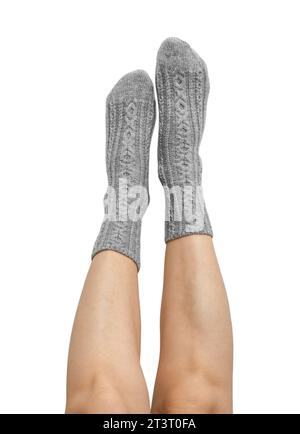 Female legs in grey hand knitted wool socks isolated on white background, clipping path included Stock Photo