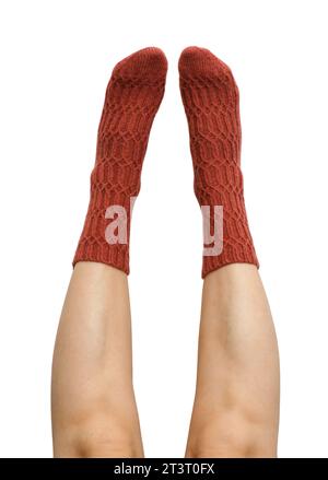 Female legs in terracotta hand knitted wool socks isolated on white background, clipping path included Stock Photo