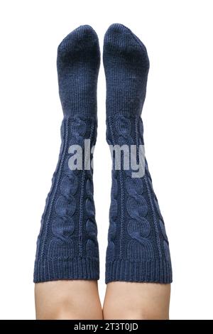 Female legs in dark blue hand knitted wool knee socks isolated on white background, clipping path included Stock Photo