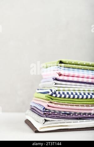 Clean kitchen textiles made of cotton and linen - napkins, towels folded on the light background Stock Photo