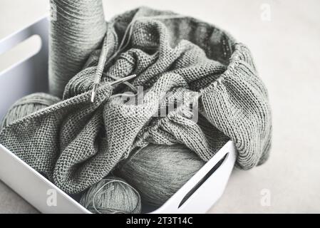Knitting project in progress. A piece of knitting with balls of yarn and a knitting needles closeup Stock Photo