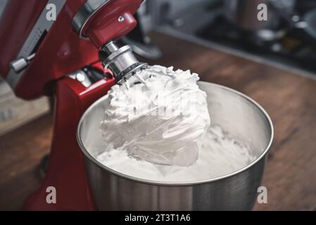 Whipped egg whites - beaten italian meringue on a wire whisk closeup Stock Photo