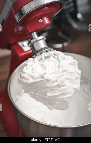 Whipped egg whites - beaten italian meringue on a wire whisk closeup Stock Photo