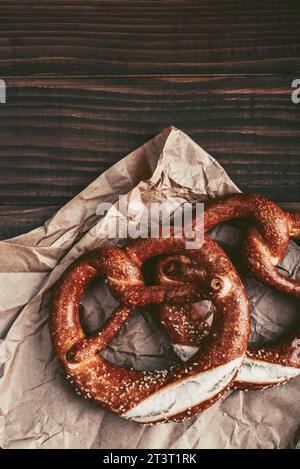 Two soft pretzels with sesame seeds on wooden background, top view Stock Photo