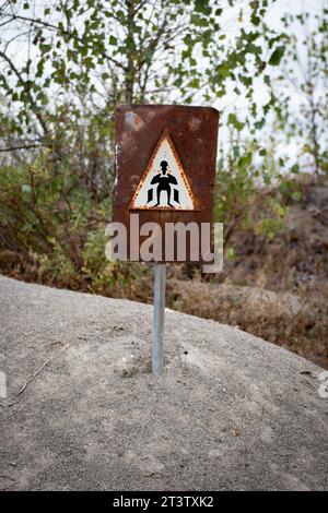 Warning signs with poles planted in the sand near a chemical plant in Parma alert of potential hazards Stock Photo