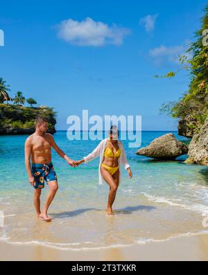A couple of men and women in swimshorts and bikinis at Playa Lagun Beach Cliff Curacao, Lagun Beach Curacao a small island in the Caribbean during a luxury summer holiday vacation Stock Photo
