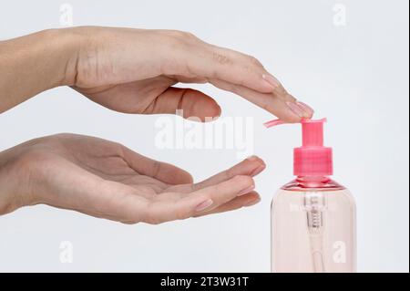 Pouring laundry detergent from bottle into cap on light grey marble table,  closeup Stock Photo - Alamy