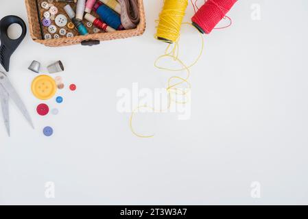 Scissor buttons thimble red yellow yarn isolated white background Stock Photo