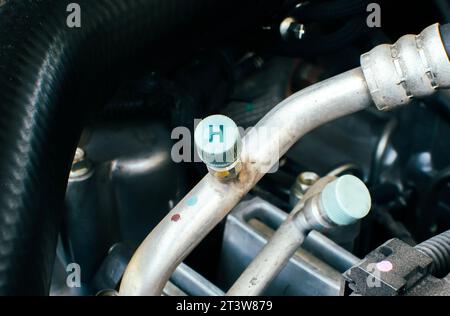 High pressure gas or liquid fill hole of car air conditioner system in a car engine compartment Automotive part concept Stock Photo