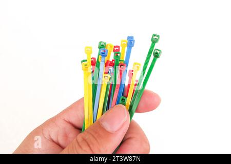 Close up of colorful plastic cable ties in hand isolated on a white background Stock Photo