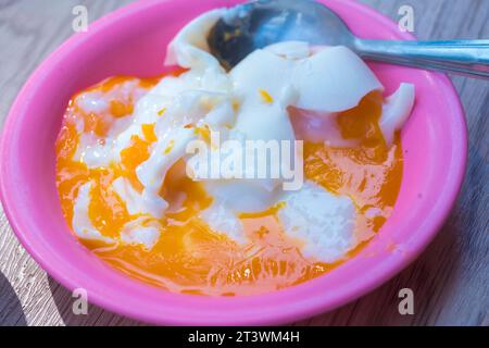 Three quarters cooked egg on a plate, with runny yolk and slightly firm whites. Stock Photo