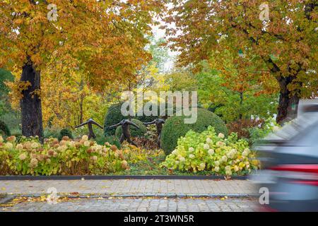 Sculpture called Five Dancing Figures of Magdalena Abakanowicz in autumnal a park beside a street Stock Photo