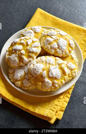 Lemon crinkle cookies on plate over dark stone background. Close up view Stock Photo