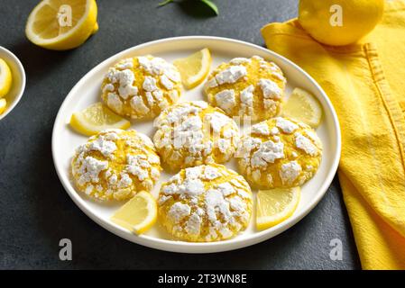 Lemon crinkle cookies on plate over dark stone background. Close up view Stock Photo
