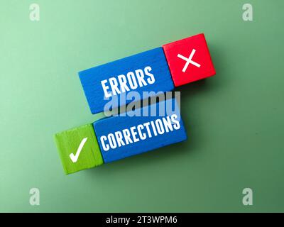 Top view colored wooden block with text CORRECTIONS ERRORS on green background. Stock Photo